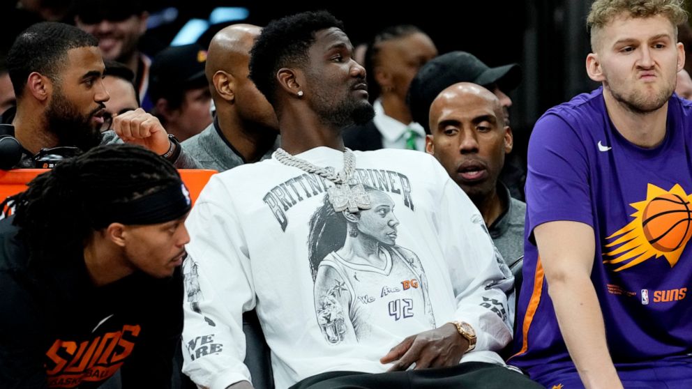 Phoenix Suns center Deandre Ayton wears a Brittney Griner shirt on the bench during the first half of an NBA basketball game against the New Orleans Pelicans, Saturday, Dec. 17, 2022, in Phoenix. (AP Photo/Matt York)