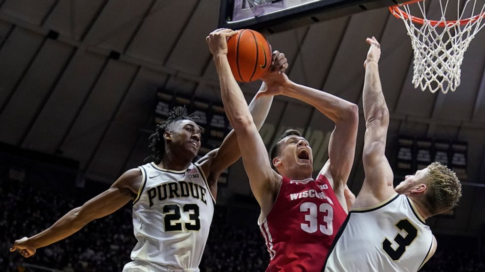 Wisconsin's Chris Vogt (33) puts up a shot against Purdue's Jaden Ivey (23) and Caleb Furst (3) during the first half of an NCAA basketball game, Monday, Jan. 3, 2022, in West Lafayette, Ind. (AP Photo/Darron Cummings)