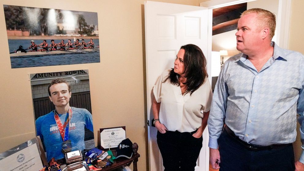 Brenda and Brian Lilly look at photos of their son Brian Lilly Jr. in their Easton, Conn. home, Thursday, Oct. 13, 2022. Brian Lilly Jr., 19, who committed suicide on Jan. 4, 2021, was a rower at University of California San Diego. The Lillys have fi