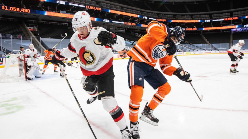 Edmonton Oilers' Jujhar Khaira (16) and Ottawa Senators' Tim Stuetzle (18) battle for the puck during the second period of an NHL hockey game, Wednesday, March 10, 2021 in Edmonton, Alberta. (Jason Franson/The Canadian Press via AP)