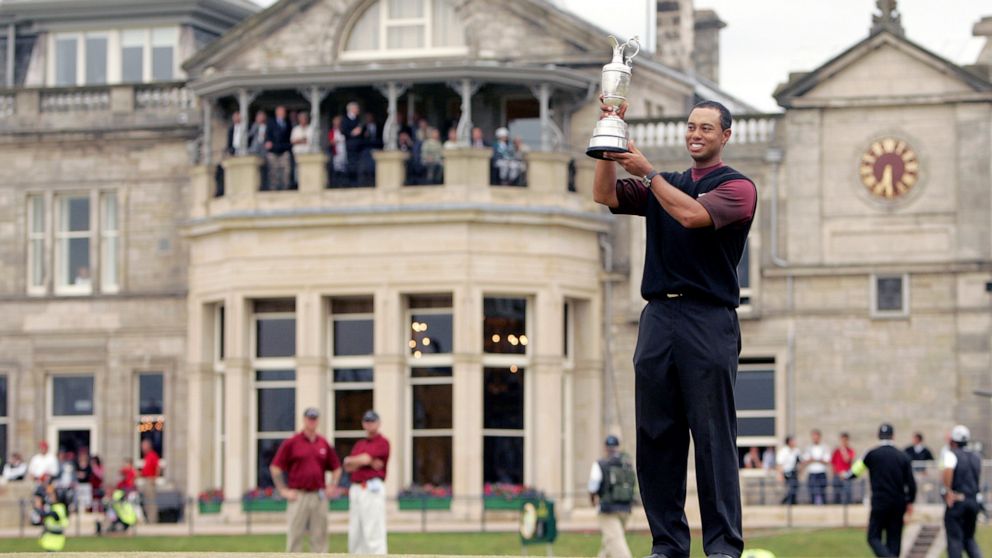 FILE - Tiger Woods holds the trophy as he stands in front of the clubhouse after winning the British Open golf championship on the Old Course at St. Andrews, Scotland, Sunday July 17, 2005. The Open Championship returns to the home of golf on July 14
