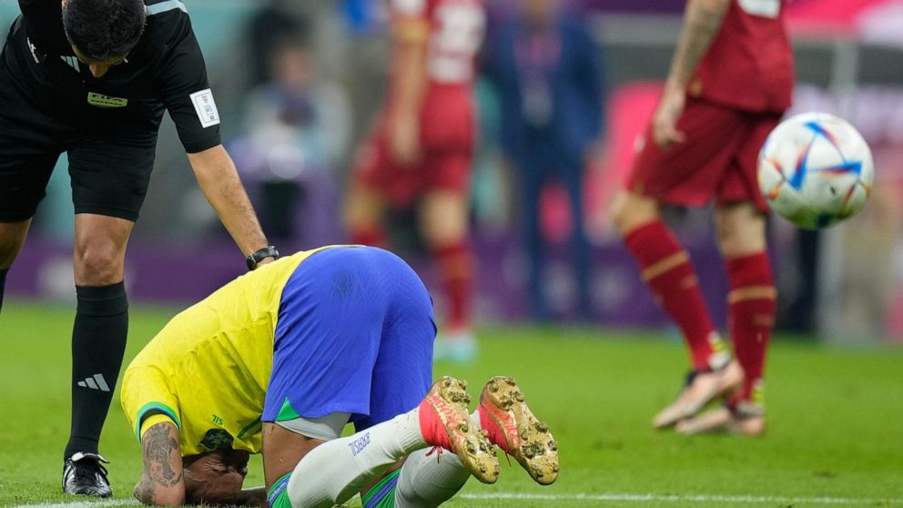 Brazil's Neymar kneels on the pitch during the World Cup group G soccer match between Brazil and Serbia, at the Lusail Stadium in Lusail, Qatar, Thursday, Nov. 24, 2022. (AP Photo/Aijaz Rahi)