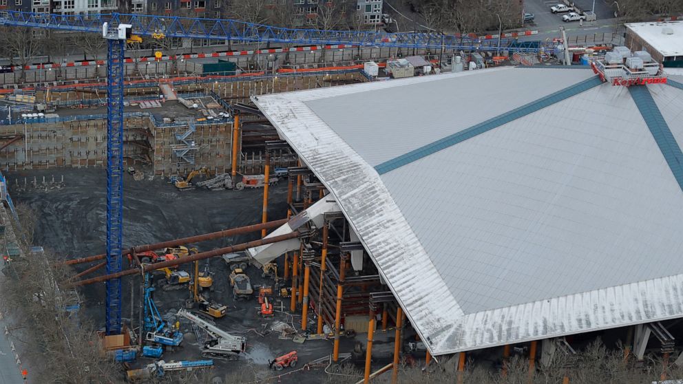 In this March 26, 2020, photo, KeyArena is shown as viewed from the Space Needle in Seattle with renovation construction temporarily halted due to the outbreak of the coronavirus. The pandemic has created questions of scheduling and worker health as 
