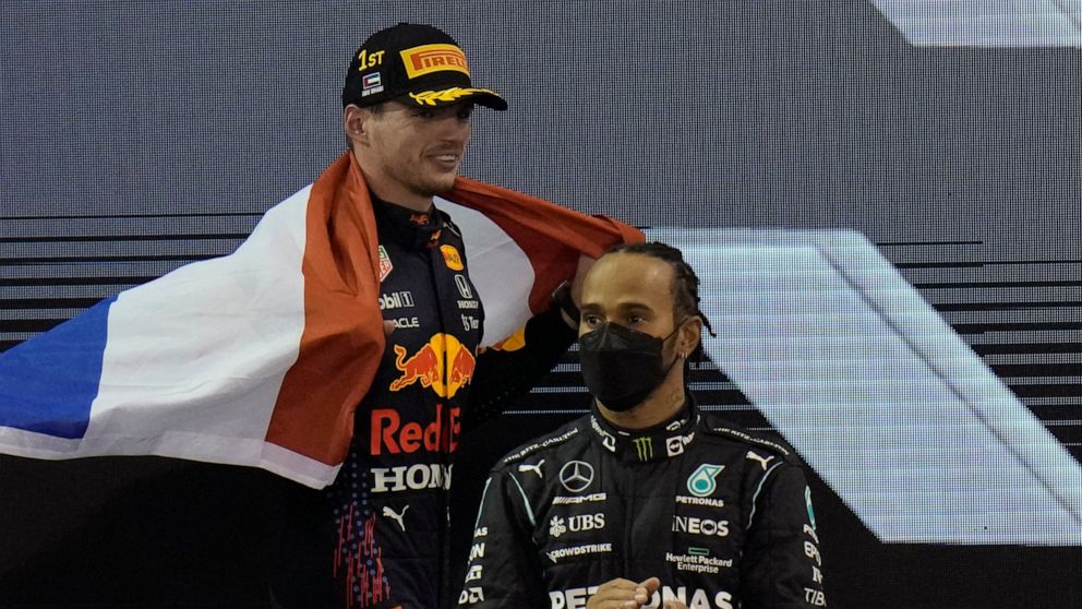 FILE - Red Bull driver Max Verstappen of the Netherlands celebrates after becoming the world champion after winning the Formula One Abu Dhabi Grand Prix in Abu Dhabi, UAE, Sunday, Dec. 12, 2021. Mercedes driver Lewis Hamilton of Britain stands in for