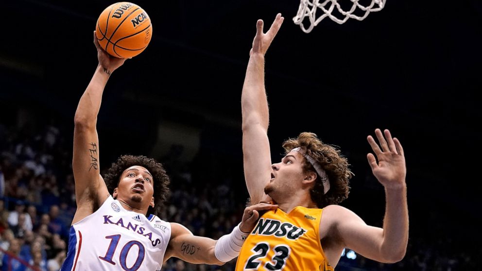 Kansas forward Jalen Wilson (10) short over North Dakota State forward Andrew Morgan (23) during the first half of an NCAA college basketball game Thursday, Nov. 10, 2022, in Lawrence, Kan. (AP Photo/Charlie Riedel)