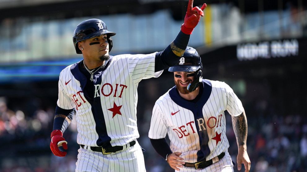 Detroit Tigers' Javier Baez, left, celebrates his two-run home run with Eric Haase against the Texas Rangers in the first inning of a baseball game in Detroit, Saturday, June 18, 2022. (AP Photo/Paul Sancya)