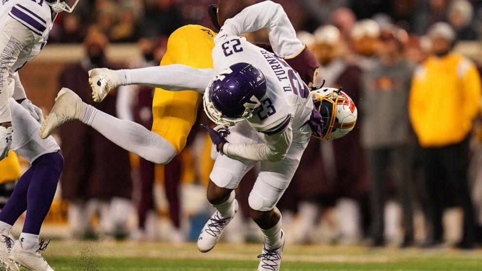 Minnesota wide receiver Dylan Wright (5) fumbles the ball after a hit by Northwestern defensive back Devin Turner (23) during the second half of an NCAA college football game Saturday, Nov. 12, 2022, in Minneapolis. (AP Photo/Abbie Parr)