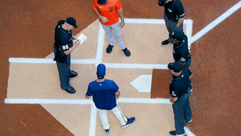 San Francisco Giants' Scott Alexander and Milwaukee Brewers' Jason Alexander exchange lineups before game 2 of a doubleheader baseball game against the San Francisco Giants Thursday, Sept. 8, 2022, in Milwaukee. (AP Photo/Morry Gash)