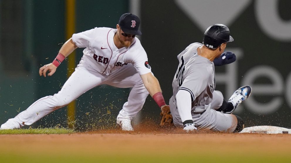 Boston Red Sox's Christian Arroyo, left, tags out New York Yankees' Aaron Judge on an attempted steal during the third inning of a baseball game Tuesday, Sept. 13, 2022, in Boston. (AP Photo/Steven Senne)