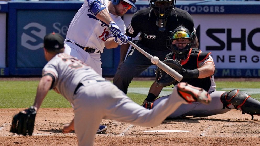 Los Angeles Dodgers' Max Muncy, second from left, hits an RBI double as San Francisco Giants starting pitcher Alex Cobb, left, watches along with catcher Joey Bart, right, and home plate umpire Malachi Moore during the third inning of a baseball game