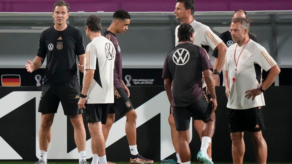 FILE - Germany's manager Oliver Bierhoff, left, talks to coaches besides head coach Hans Flick, right, prior to a training session at the Al-Shamal stadium on the eve of the group E World Cup soccer match between Germany and Costa Rica, in Al-Ruwais,