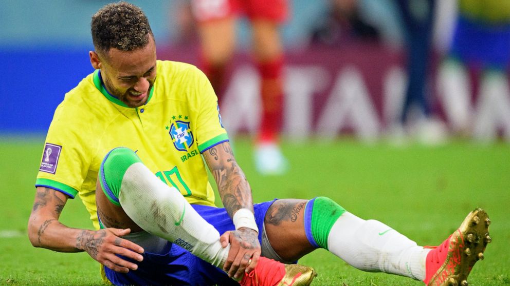 Brazil's Neymar grabs his ankle after an injury during the World Cup group G soccer match between Brazil and Serbia, at the the Lusail Stadium in Lusail, Qatar on Thursday, Nov. 24, 2022. (Laurent Gillieron/Keystone via AP)
