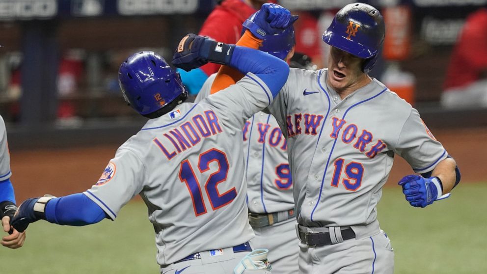 New York Mets' Mark Canha (19) celebrates with Francisco Lindor (12) after hitting a grand slam in the fourth inning of a baseball game against the Miami Marlins, Saturday, Sept. 10, 2022, in Miami. (AP Photo/Marta Lavandier)