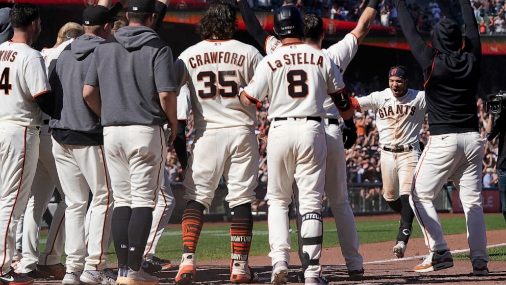 San Francisco Giants' Thairo Estrada, second from right, celebrates with teammates after hitting a two-run home run against the Pittsburgh Pirates during the ninth inning of a baseball game in San Francisco, Sunday, Aug. 14, 2022. (AP Photo/Jeff Chiu)