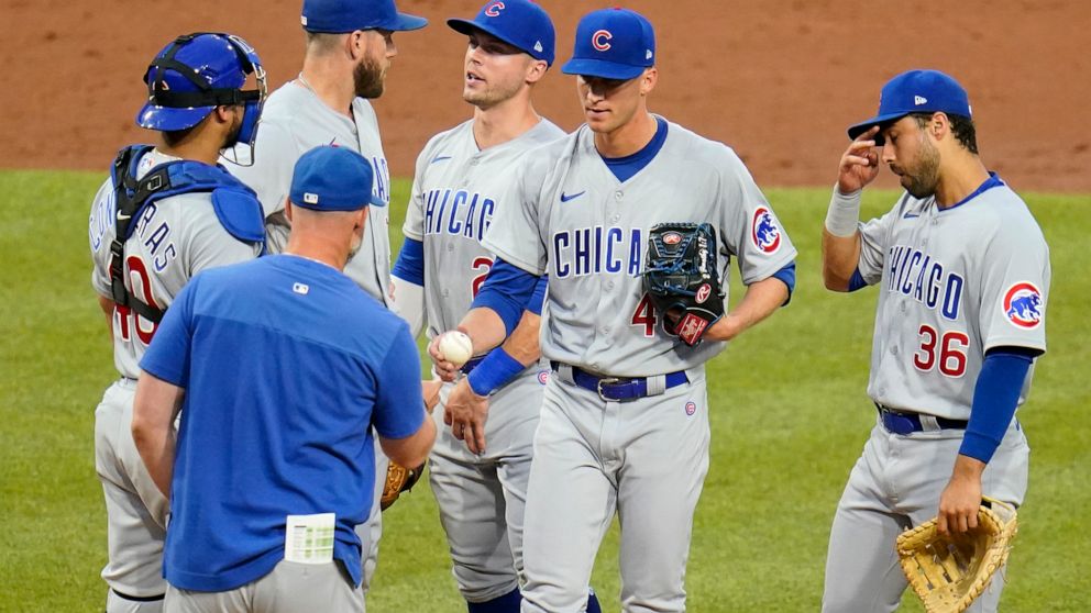 Chicago Cubs starting pitcher Caleb Kilian, center, hands the ball to manager David Ross during a pitching change in the third inning of a baseball game against the Pittsburgh Pirates in Pittsburgh, Monday, June 20, 2022. (AP Photo/Gene J. Puskar)