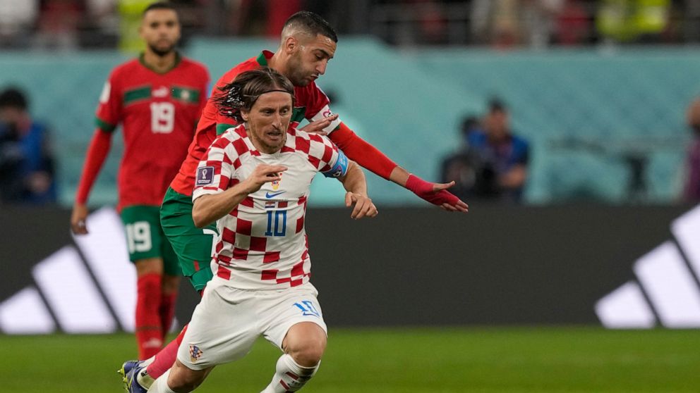 Croatia's Luka Modric, front, duels for the ball with Morocco's Hakim Ziyech during the World Cup third-place playoff soccer match between Croatia and Morocco at Khalifa International Stadium in Doha, Qatar, Saturday, Dec. 17, 2022. (AP Photo/Frank A