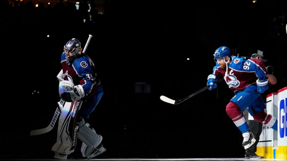 Colorado Avalanche goaltender Darcy Kuemper (35) and left wing Gabriel Landeskog (92) take the ice before Game 1 of the team's NHL hockey Stanley Cup playoffs Western Conference finals against the Edmonton Oilers on Tuesday, May 31, 2022, in Denver. 