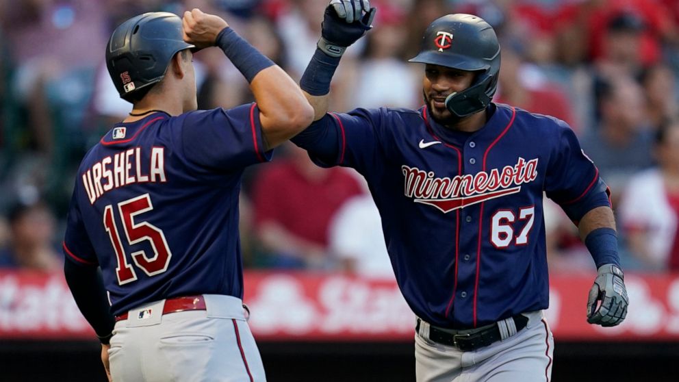 Minnesota Twins' Gilberto Celestino (67) celebrates with Gio Urshela (15) after hitting a home run during the second inning of a baseball game in Anaheim, Calif., Friday, Aug. 12, 2022. Urshela also scored. (AP Photo/Ashley Landis)