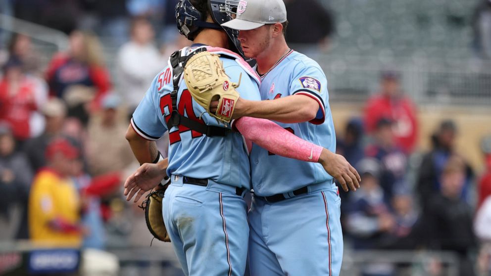 Minnesota Twins relief pitcher Emilio Pagan, right, celebrates with catcher Gary Sanchez (24) after defeating the Oakland Athletics in a baseball game Sunday, May 8, 2022, in Minneapolis. (AP Photo/Stacy Bengs)