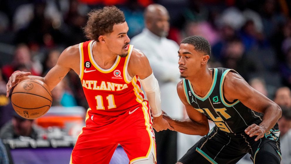 Atlanta Hawks guard Trae Young (11) is guarded by Charlotte Hornets guard Theo Maledon (9) during the first half of an NBA basketball game Friday, Dec. 16, 2022, in Charlotte, N.C. (AP Photo/Rusty Jones)