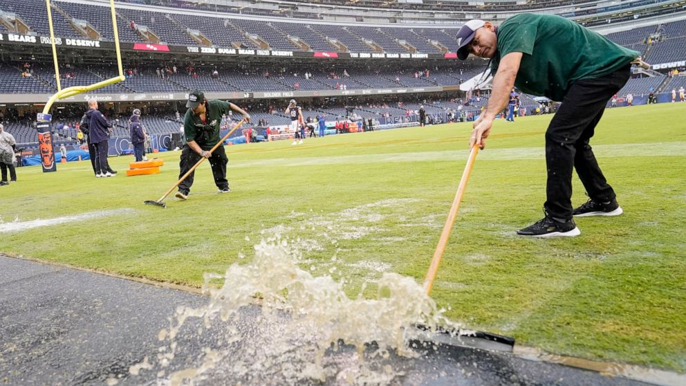 Workers remove water from Soldier Field before an NFL football game between the Chicago Bears and the San Francisco 49ers Sunday, Sept. 11, 2022, in Chicago. (AP Photo/Charles Rex Arbogast)