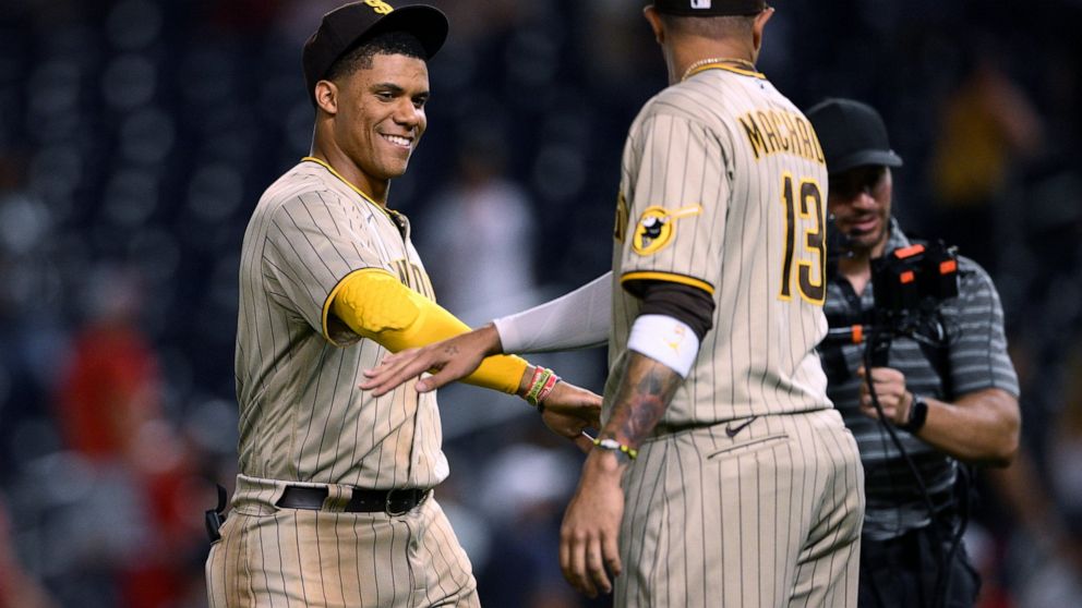 San Diego Padres' Juan Soto, left, celebrates with Manny Machado after the team's baseball game against the Washington Nationals, Friday, Aug. 12, 2022, in Washington. The Padres won 10-5. (AP Photo/Nick Wass)