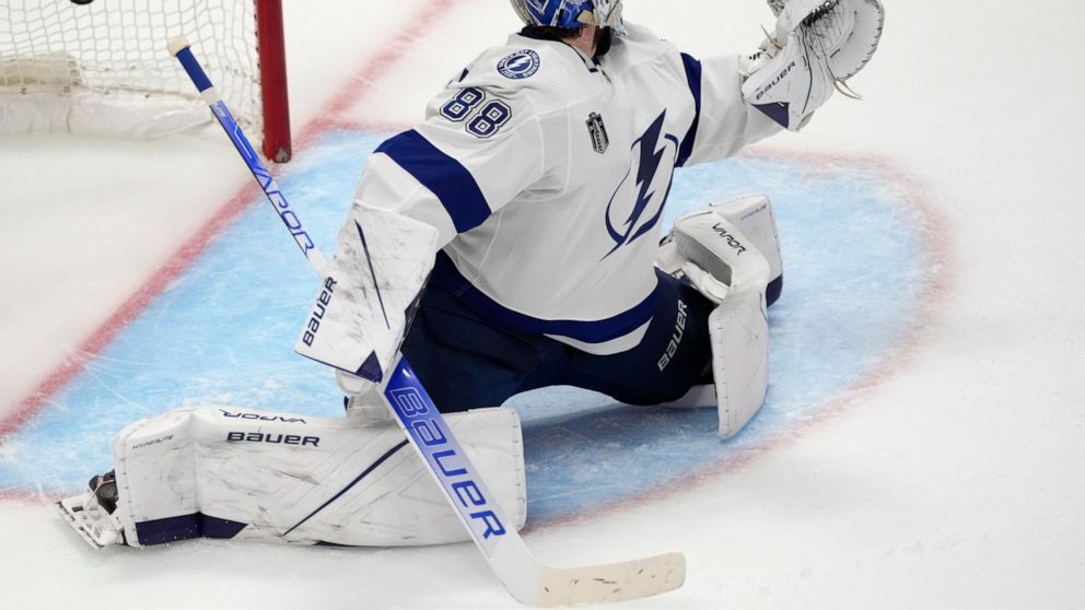 Tampa Bay Lightning goaltender Andrei Vasilevskiy looks back as the puck enters the net for a goal by Colorado Avalanche center Darren Helm during the second period in Game 2 of the NHL hockey Stanley Cup Final on Saturday, June 18, 2022, in Denver. 