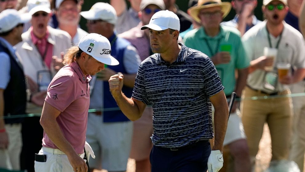 FILE - Scottie Scheffler pumps his fist as walks past Cameron Smith, of Australia, after a birdie chip on the third hole during the final round at the Masters golf tournament on Sunday, April 10, 2022, in Augusta, Ga. The hole was the turning point i