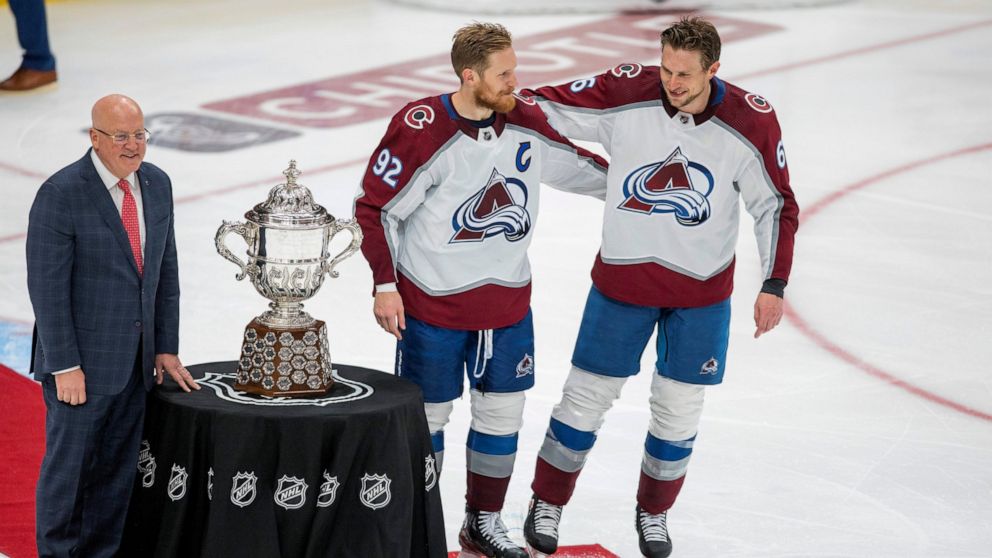 Colorado Avalanche's Gabriel Landeskog (92) and Erik Johnson (6) stand with the Campbell Conference Bowl as Deputy Commissioner Bill Daley looks on after overtime NHL hockey conference finals action in Edmonton, Alberta, on Monday, June 6, 2022. The 