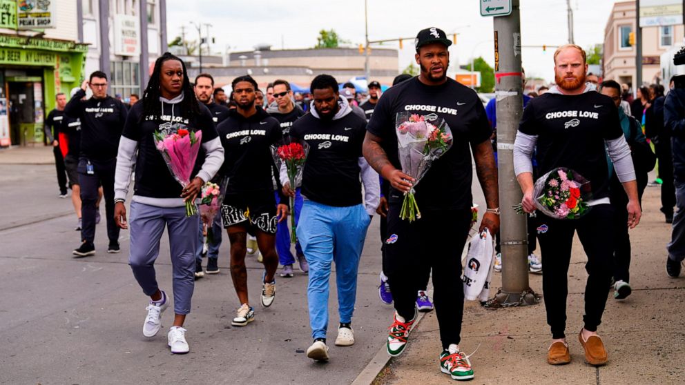 Members of the Buffalo Bills make their way to the scene of Saturday's shooting at a supermarket, in Buffalo, N.Y., Wednesday, May 18, 2022. (AP Photo/Matt Rourke)