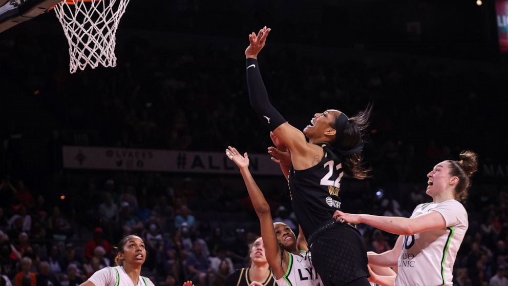 Las Vegas Aces forward A'ja Wilson (22) lays up the ball between Minnesota Lynx guard Moriah Jefferson (4) and forward Jessica Shepard (10) during the second half of a WNBA basketball game Sunday, June 19, 2022, in Las Vegas. (Chase Stevens/Las Vegas