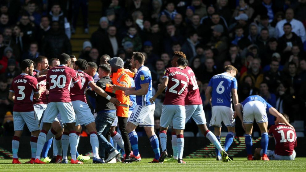A fan is removed after attacking Aston Villa's Jack Grealish, right, on the pitch during the Sky Bet Championship soccer match at St Andrew's Trillion Trophy Stadium, Birmingham, England, Sunday March 10, 2019. (Nick Potts/PA via AP)