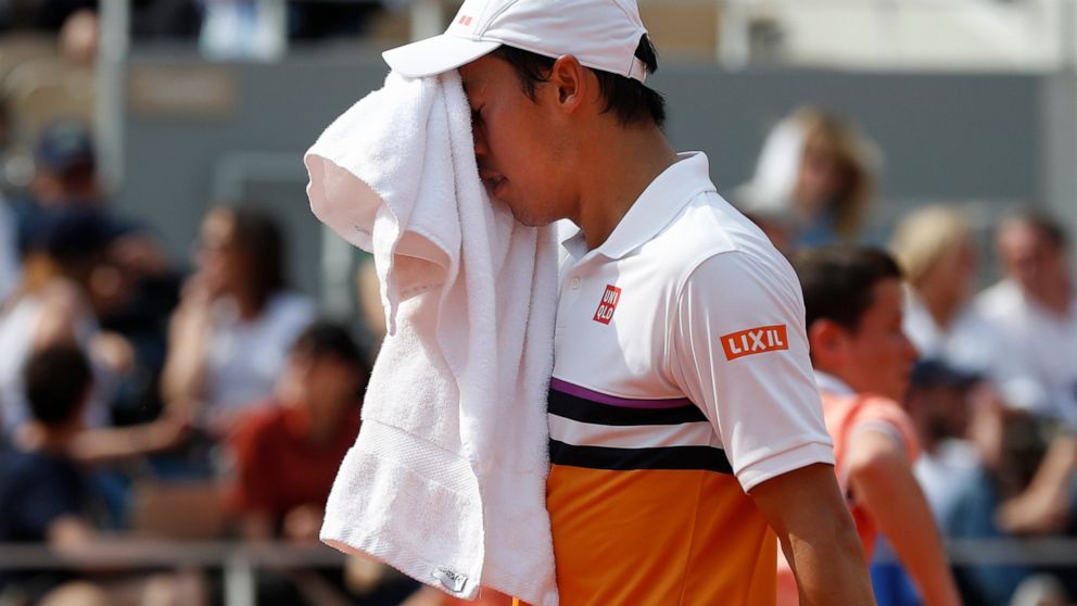 Japan's Kei Nishikori uses a towel during his quarterfinal match of the French Open tennis tournament against Spain's Rafael Nadal at the Roland Garros stadium in Paris, Tuesday, June 4, 2019. (AP Photo/Pavel Golovkin)