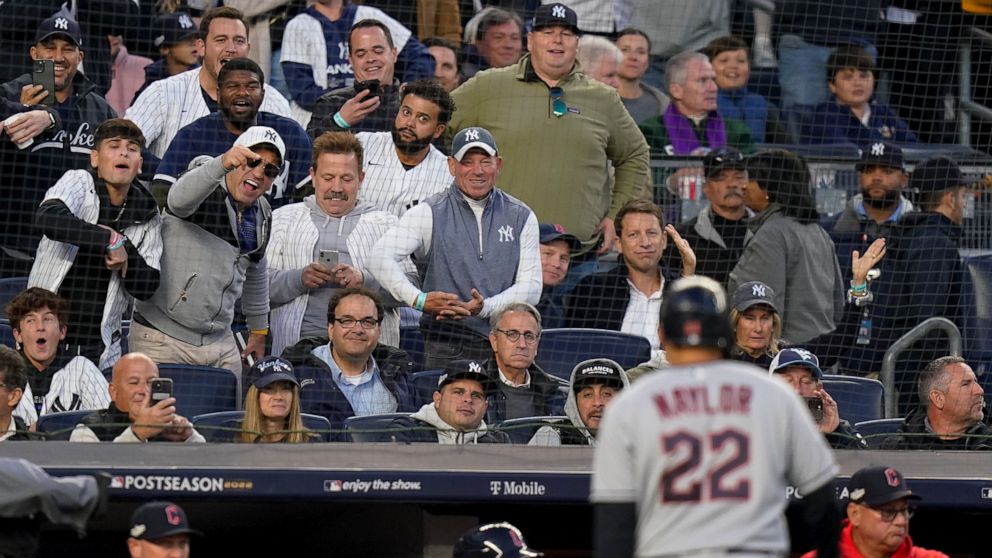 New York Yankees fans shout as Cleveland Guardians Josh Naylor (22) walks back to the dugout after lining out during the sixth inning of Game 5 of an American League Division baseball series against the New York Yankees, Tuesday, Oct. 18, 2022, in Ne