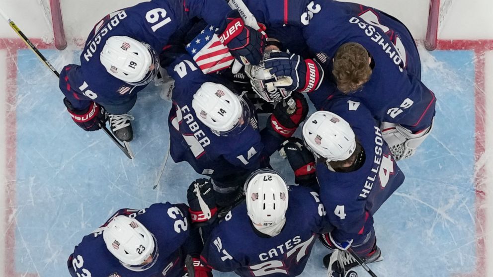 United States players console goalkeeper Strauss Mann after losing to Slovakia 3-2 in a shoot-out in a men's quarterfinal hockey game at the 2022 Winter Olympics, Wednesday, Feb. 16, 2022, in Beijing. (AP Photo/Matt Slocum)