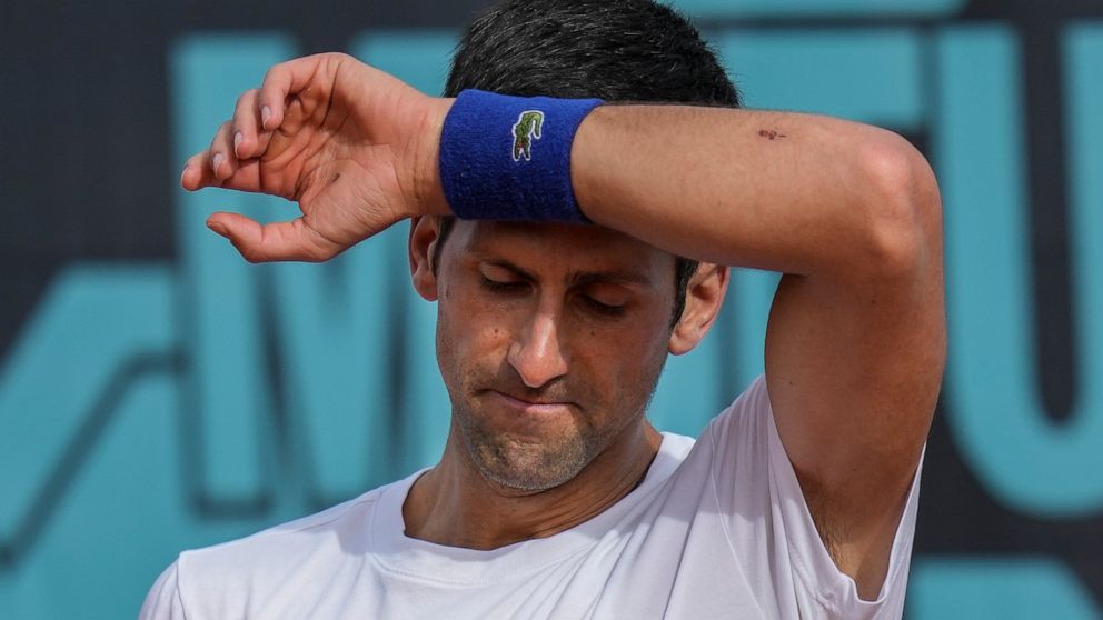 FILE - Novak Djokovic, of Serbia, wipes the sweat off during a training session at the Mutua Madrid Open tennis tournament in Madrid, Spain, on April 30, 2022. Djokovic withdrew from the upcoming hard-court tournament in Montreal on Thursday, AUg. 4,