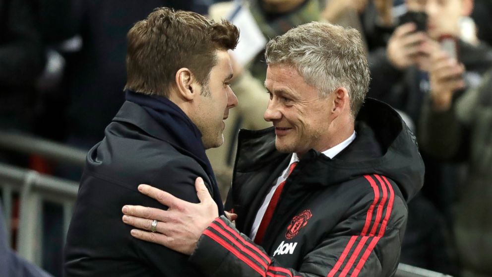 Manchester United caretaker manager Ole Gunnar Solskjaer, right, greets Tottenham manager Mauricio Pochettino, left, prior to the English Premier League soccer match between Tottenham Hotspur and Manchester United at Wembley stadium in London, Englan