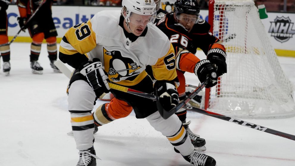Pittsburgh Penguins left wing Jake Guentzel, left, vies for the puck against Anaheim Ducks defenseman Brandon Montourn during the first period of an NHL hockey game in Anaheim, Calif., Friday, Jan. 11, 2019. (AP Photo/Chris Carlson)