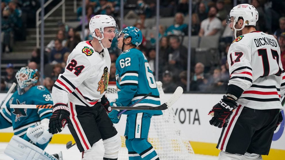 Chicago Blackhawks center Sam Lafferty (24) celebrates with Jason Dickinson (17) after scoring against the San Jose Sharks during the second period of an NHL hockey game in San Jose, Calif., Saturday, Oct. 15, 2022. (AP Photo/Godofredo A. Vásquez)