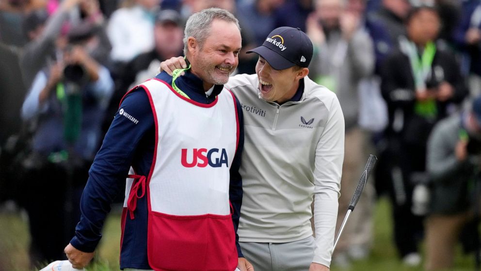 Matthew Fitzpatrick, of England, celebrates with his caddie after winning the U.S. Open golf tournament at The Country Club, Sunday, June 19, 2022, in Brookline, Mass. (AP Photo/Charlie Riedel)