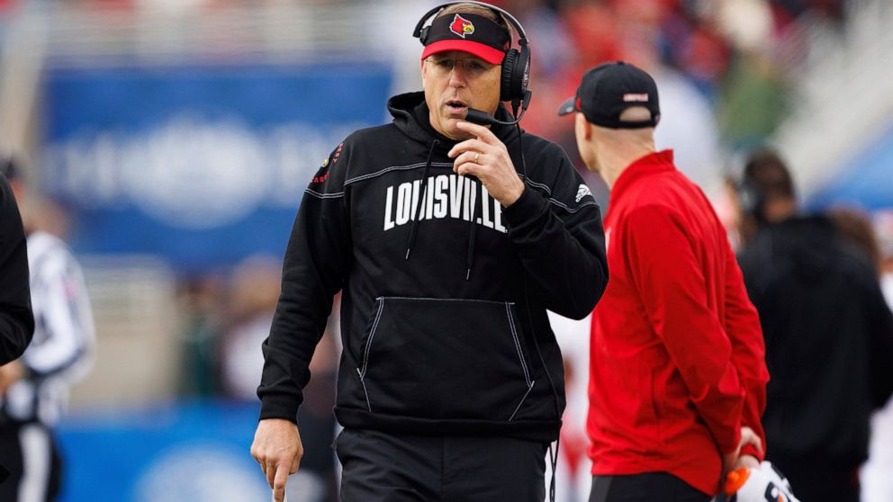 Louisville head coach Scott Satterfield walks down the sideline during the first half of an NCAA college football game in Lexington, Ky., Saturday, Nov. 26, 2022. (AP Photo/Michael Clubb)