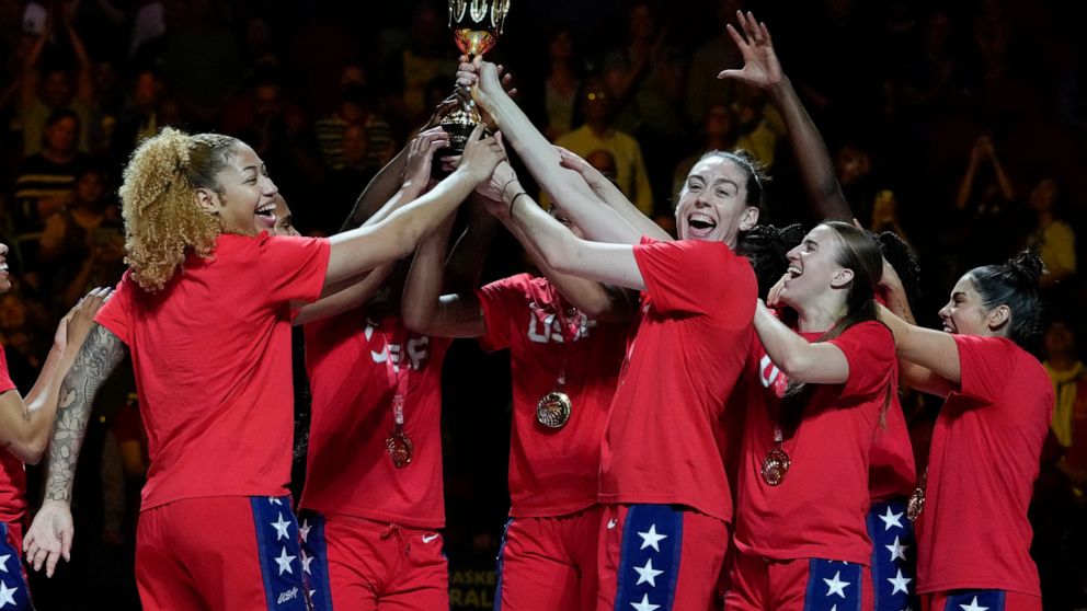 Gold medalists the United States hold their trophy aloft as they celebrate on the podium after defeating China in the final at the women's Basketball World Cup in Sydney, Australia, Saturday, Oct. 1, 2022. (AP Photo/Mark Baker)