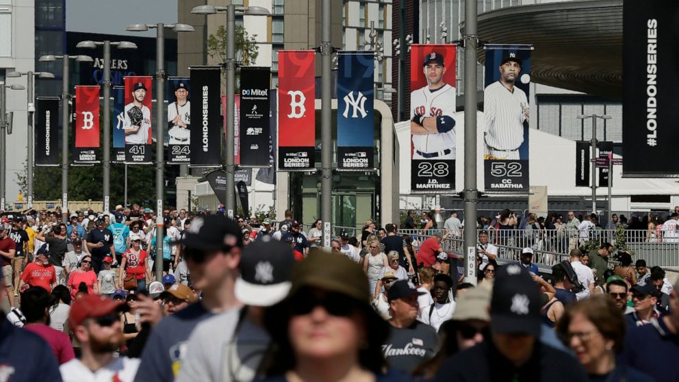 FILE - In this June 29, 2019, file photo, fans arrive before a baseball game between the Boston Red Sox and the New York Yankees, in London. Major League Baseball is trying to muscle in on a crowded marketplace in Britain dominated by soccer but also