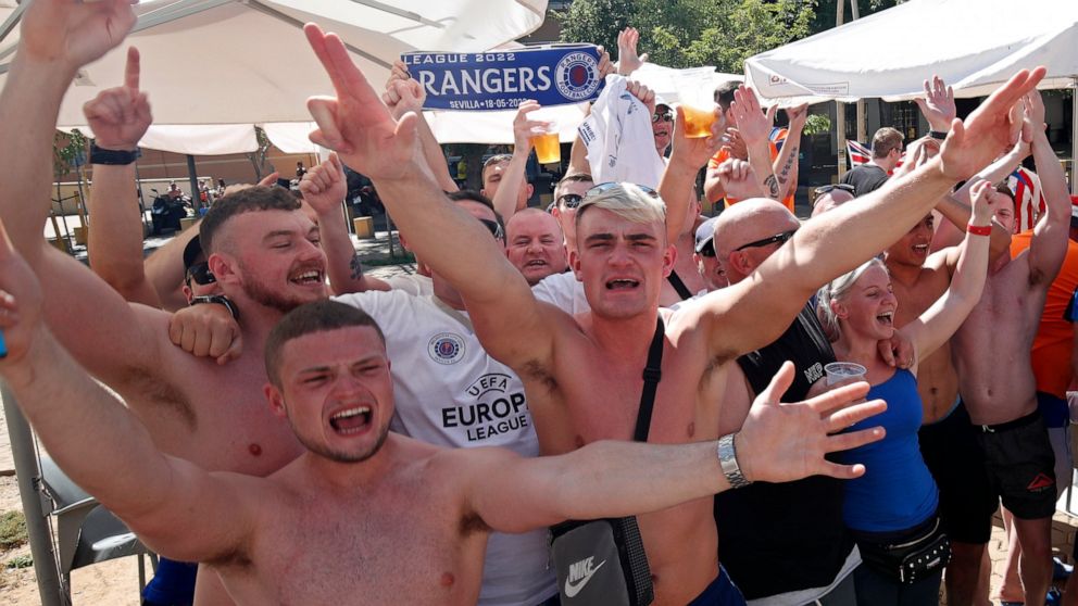 Glasgow Rangers supporters cheer outside a bar in downtown Seville, Spain, Tuesday, May 17, 2022. Eintracht Frankfurt will play Glasgow Rangers in the Europa League final Wednesday evening in Seville. (AP Photo/Angel Fernandez)