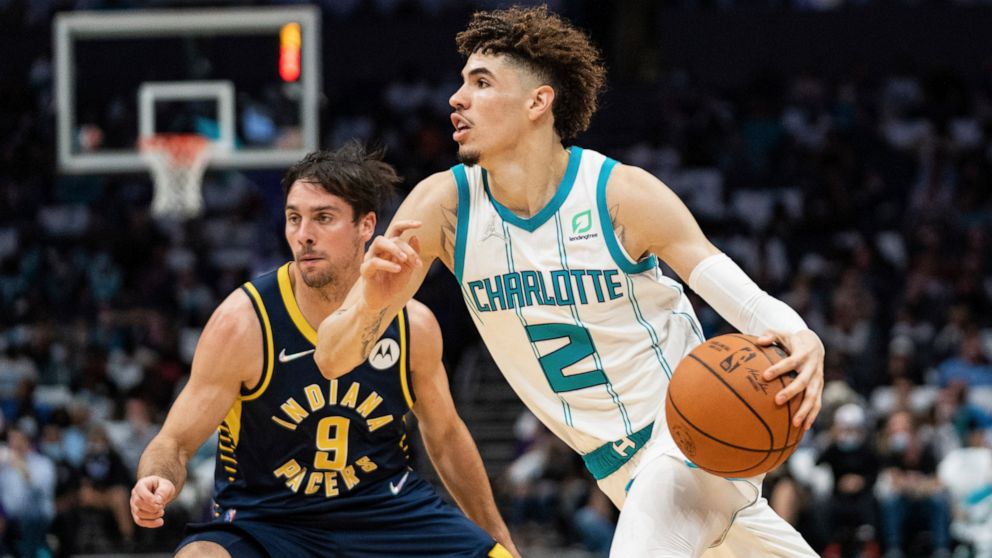 Charlotte Hornets guard LaMelo Ball (2) drives to the basket while guarded by Indiana Pacers guard T.J. McConnell (9) during the first half of an NBA basketball game in Charlotte, N.C., Wednesday, Oct. 20, 2021. (AP Photo/Jacob Kupferman)