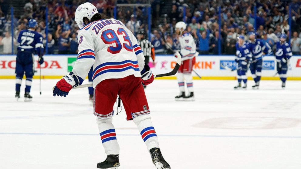 New York Rangers center Mika Zibanejad (93) skates off as members of the Tampa Bay Lightning celebrate a goal by Ondrej Palat during the third period in Game 4 of the NHL hockey Stanley Cup playoffs Eastern Conference finals Tuesday, June 7, 2022, in