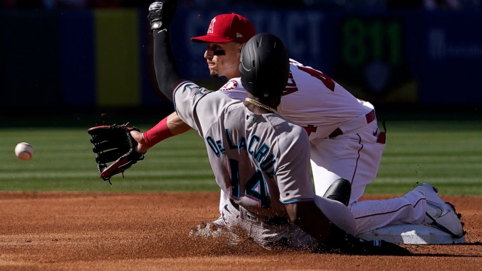 Miami Marlins' Bryan De La Cruz, left, is safe at second on a passed ball as Los Angeles Angels shortstop Andrew Velazquez takes a late throw during the second inning of a baseball game Tuesday, April 12, 2022, in Anaheim, Calif. (AP Photo/Mark J. Te