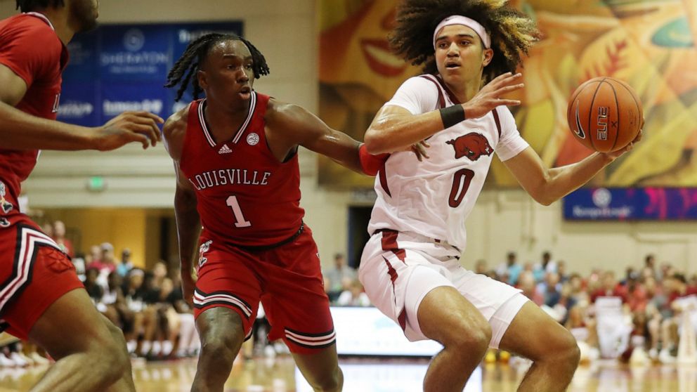 Louisville guard Mike James (1) guards against Arkansas guard Anthony Black (0) during the first half of an NCAA college basketball game, Monday, Nov. 21, 2022, in Lahaina, Hawaii. (AP Photo/Marco Garcia)
