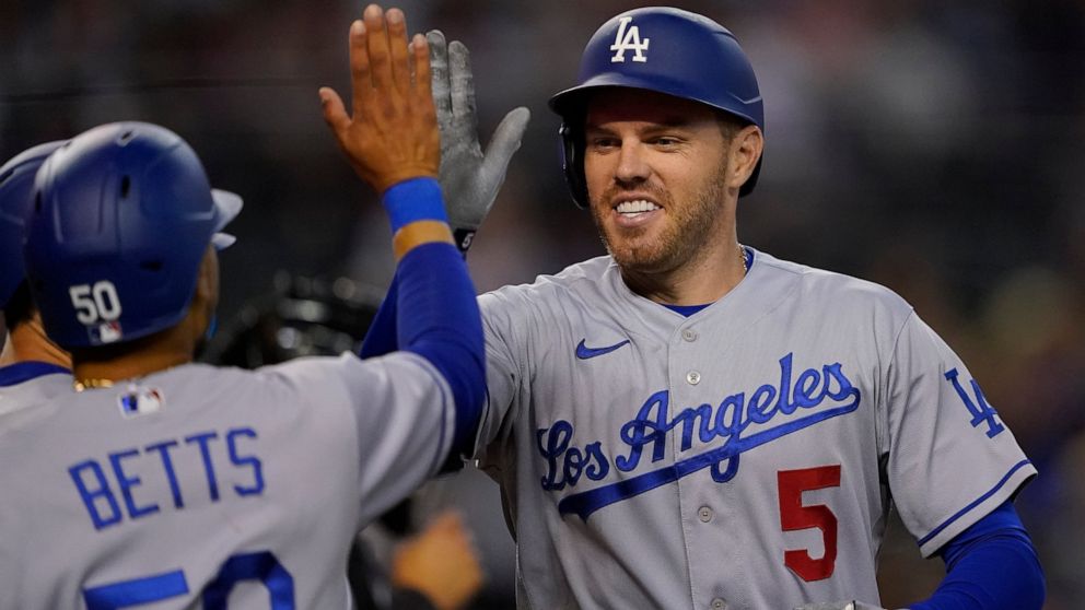 Los Angeles Dodgers' Freddie Freeman (5) high fives Mookie Betts (50) after hitting a three-run home run against the Arizona Diamondbacks during the second inning of a baseball game, Thursday, May 26, 2022, in Phoenix. (AP Photo/Matt York)