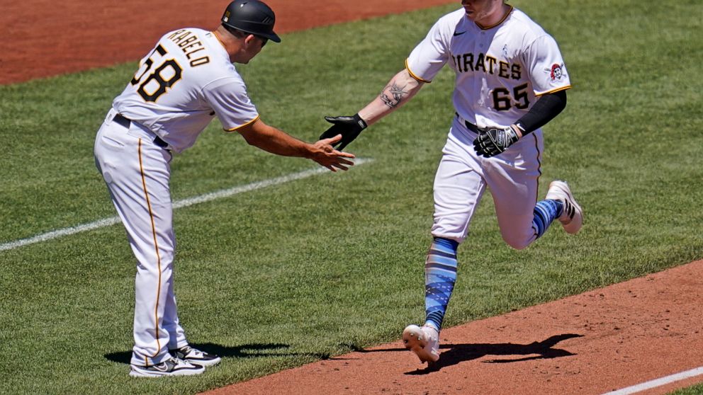 Pittsburgh Pirates' Jack Suwinski (65) is greeted by third base coach Mike Rabelo as he rounds third after hitting a solo home run off San Francisco Giants starting pitcher Alex Cobb during the fourth inning of a baseball game in Pittsburgh, Sunday, 
